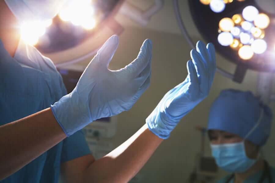 En kirurg iført blå kirurgiske hansker.