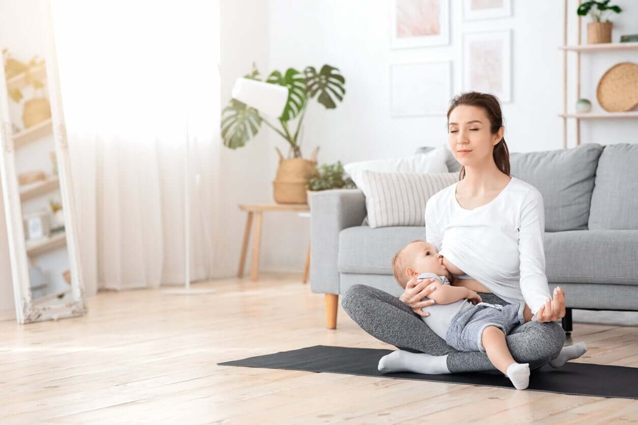 A woman meditating while she breastfeeds.