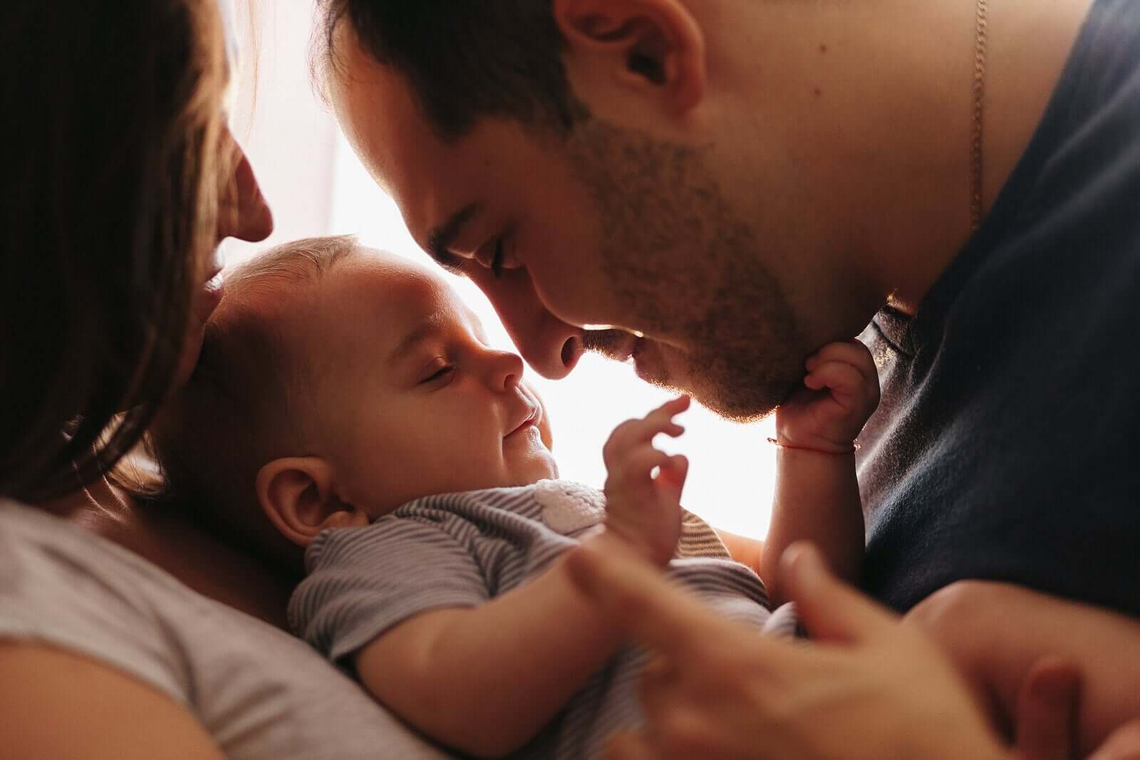 Parents nuzzling their baby boy.