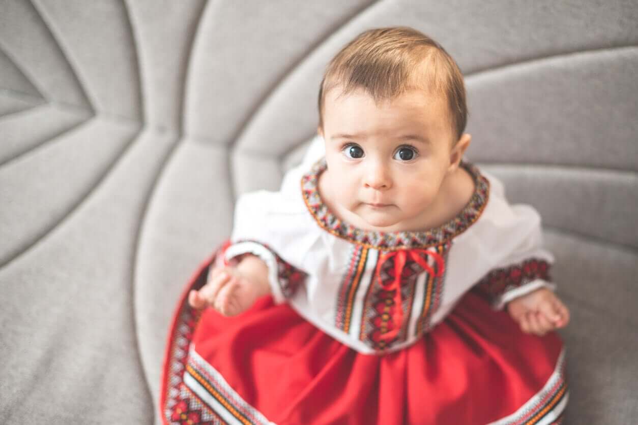 A baby wearing a Romanian dress.
