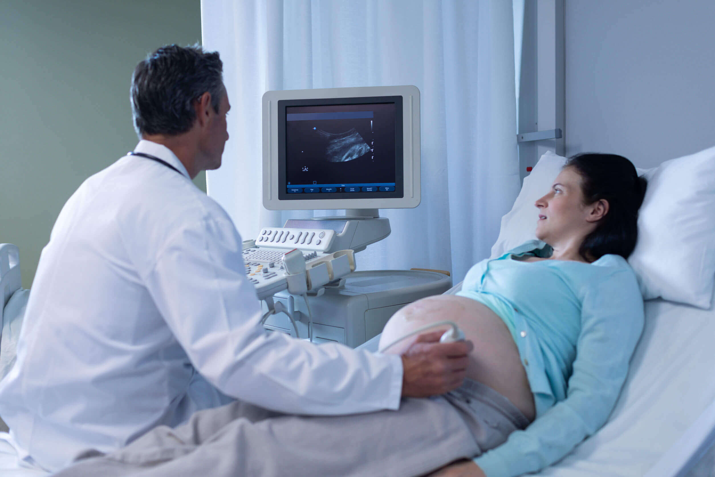 A pregnant woman in her third trimester getting an ultrasound.
