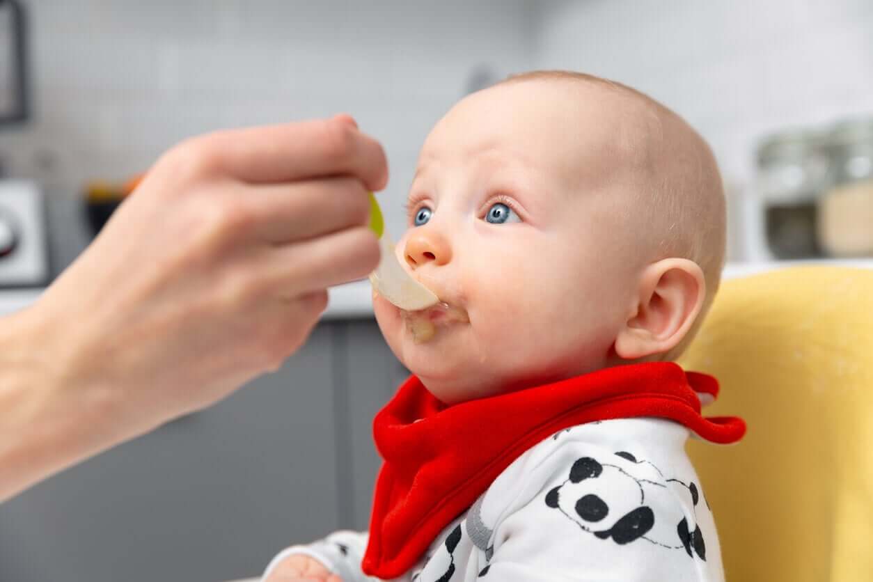 A person spoonfeeding a baby.