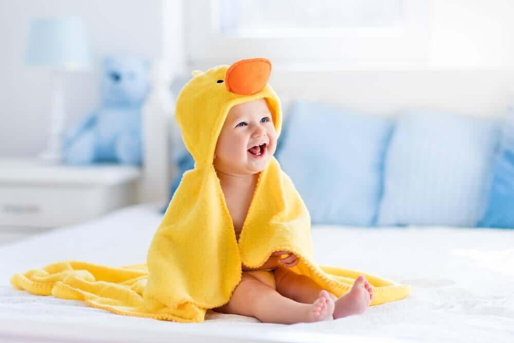 En baby pakket inn i et håndkle i form av en and.