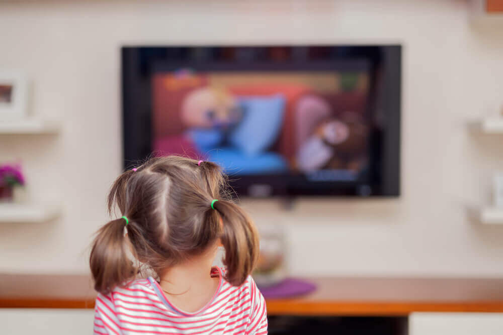 En liten flicka som tittar på tv.