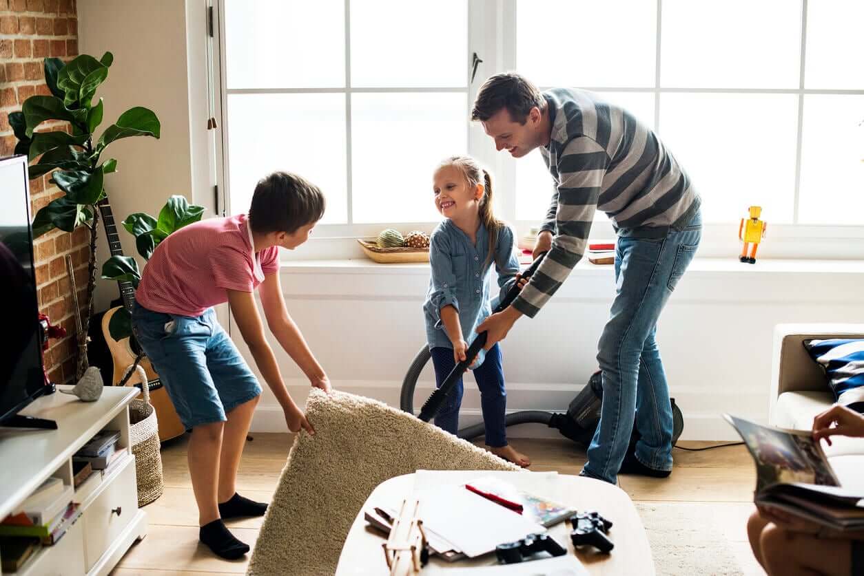 A father and his children cleaning the home together.