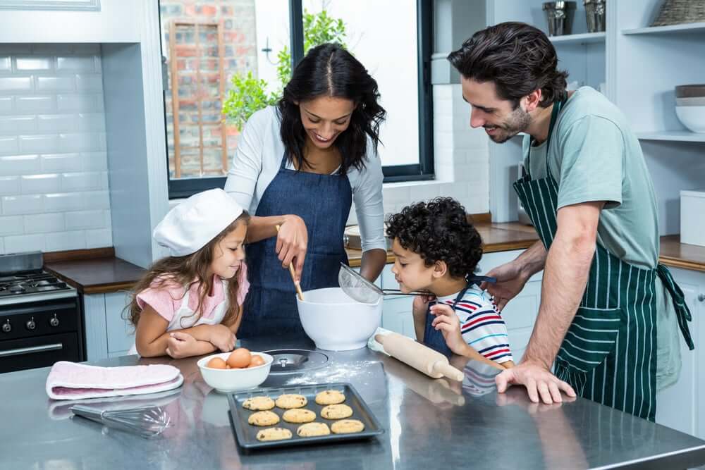 Parents cooking with their son and daughter.