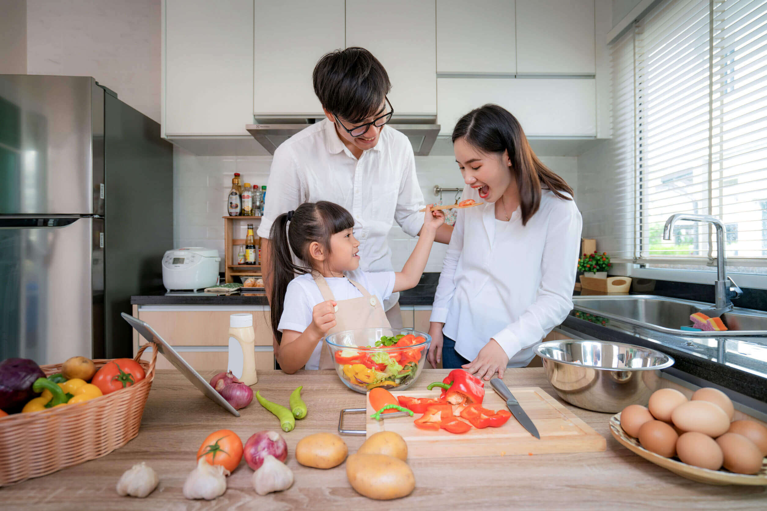 Parents cooking with their daughter.