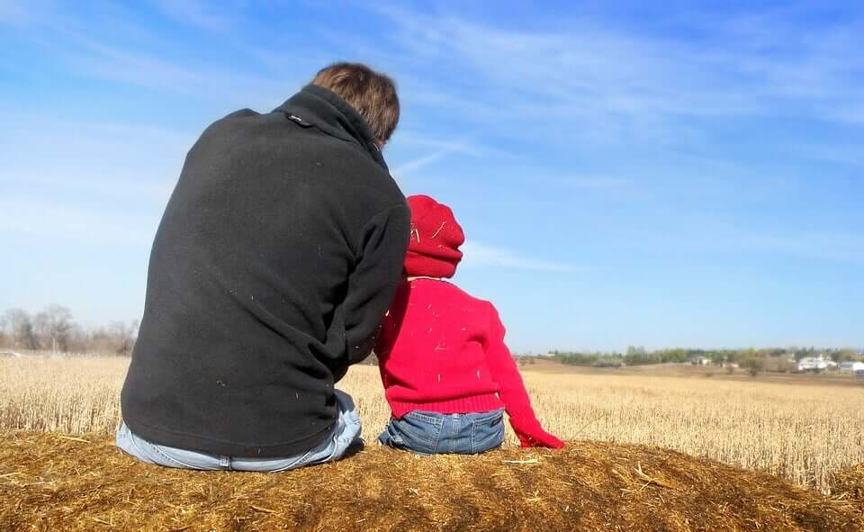 A father and his child looking out at a field.
