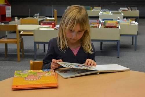 A young girl reading books at the library.