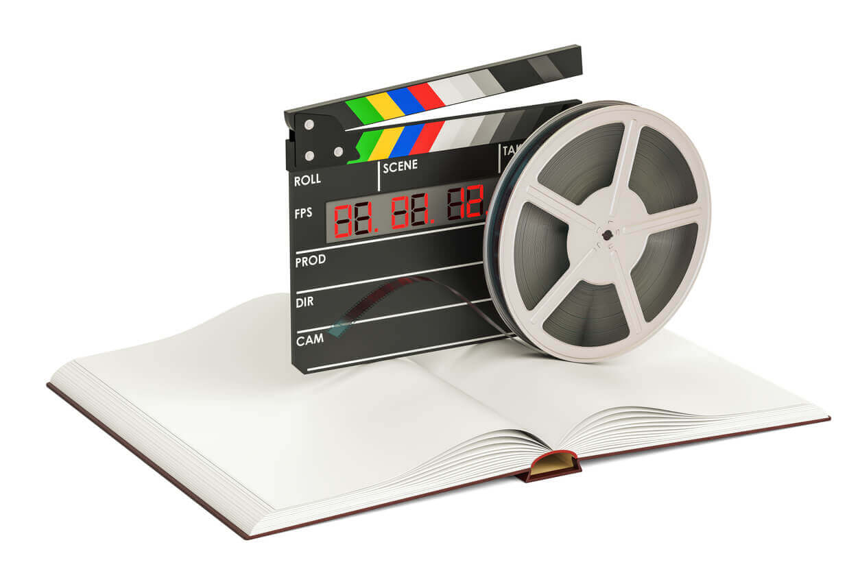 An open notebook with film and a clapperboard on top.