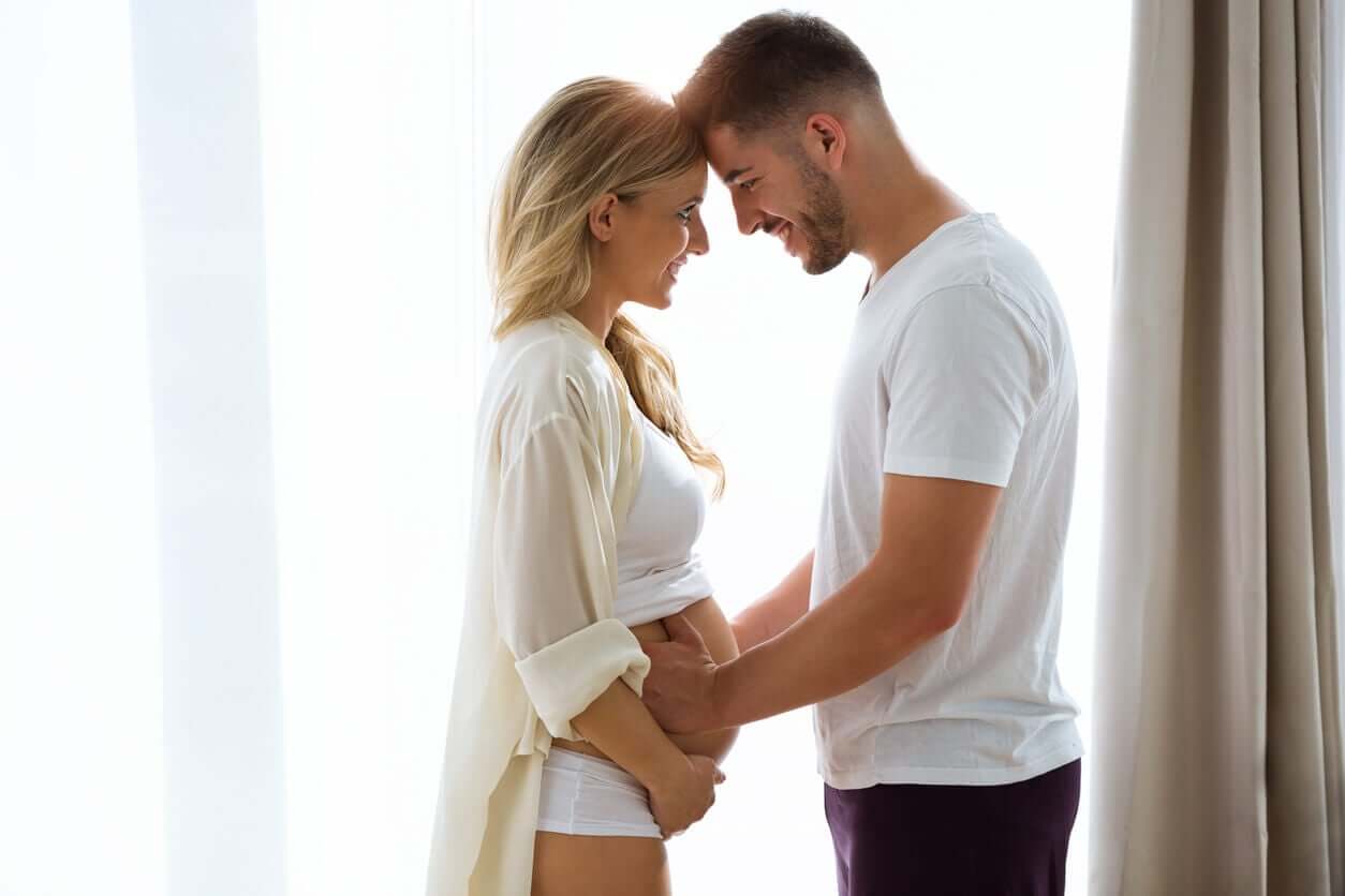 Smilende par, hvor kvinden er gravid