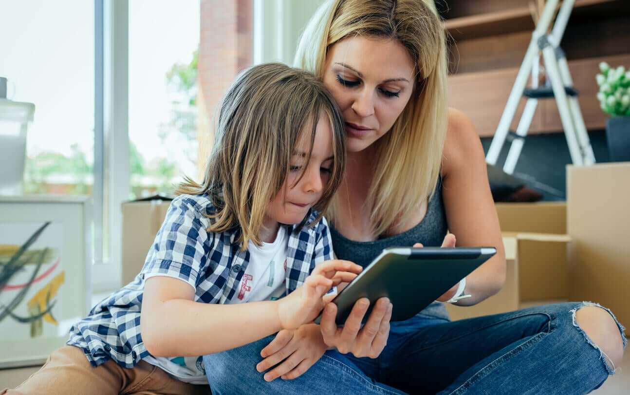 A mother using a tablet with her child.