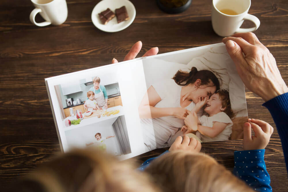 A grandmother and grandchild looking at a family album.