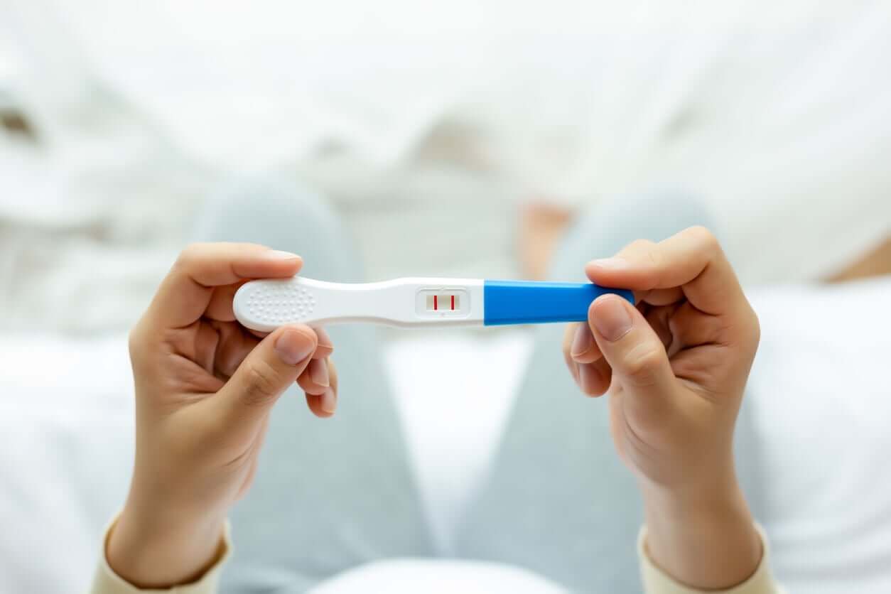 A woman holding a positive pregnancy test.