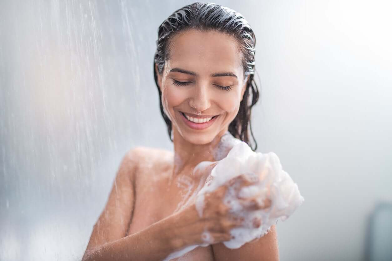 A woman sudzing up in the shower.