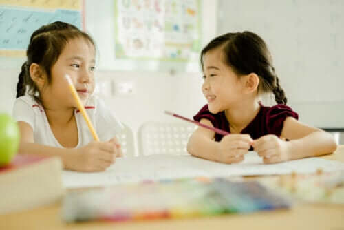 Two young girls learning to write.
