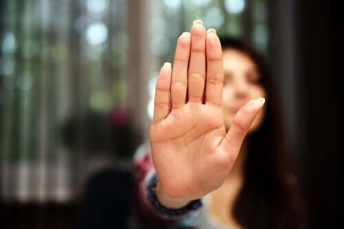 A woman holding her hand up as if to say "stop".