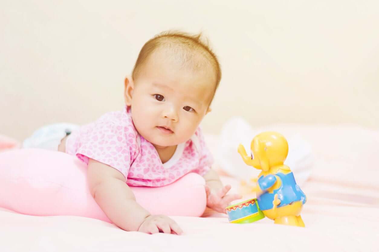 Een baby ligt op haar buik