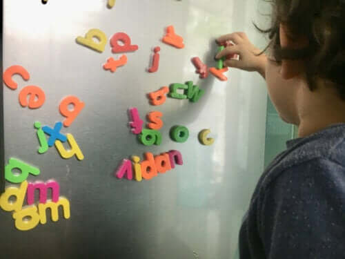 Ett barn som leker med magnetiska bokstäver.