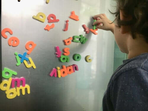 A child playing with magnetic letters.