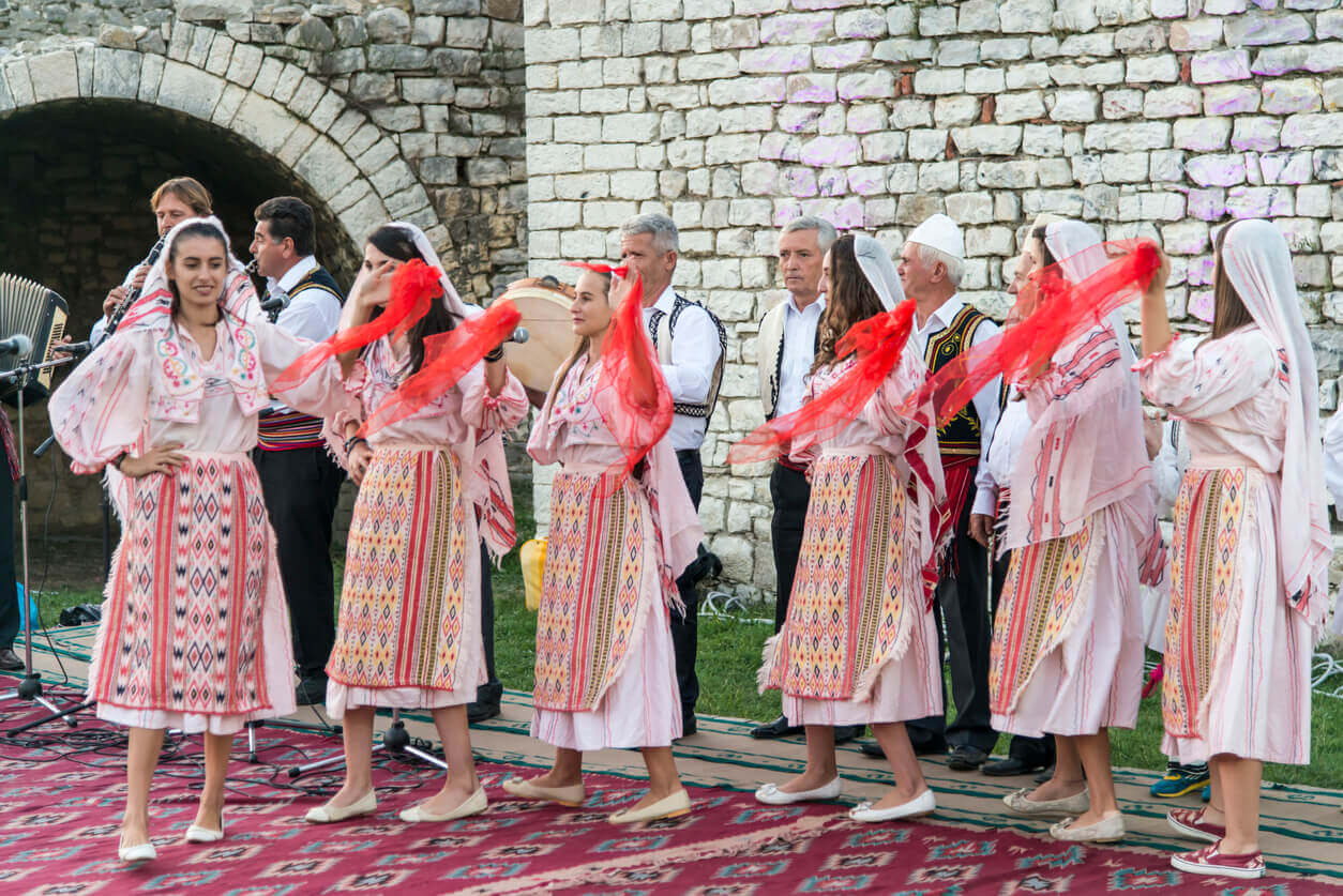 Albanian women in traditional dress doing a traditional dance.