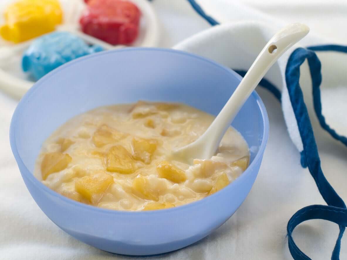 A bowl of cereal puree with chunks of fruit.