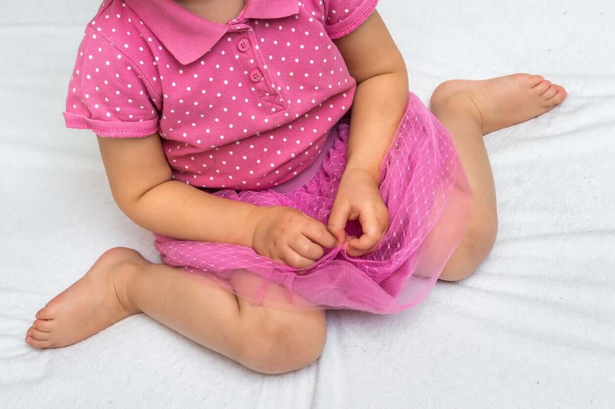 A toddler girl sitting in a W position.