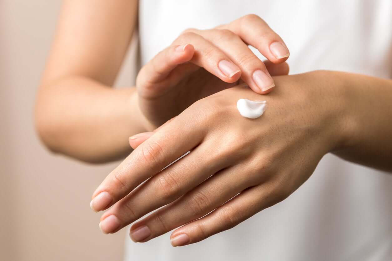 A woman putting lotion on her hands.