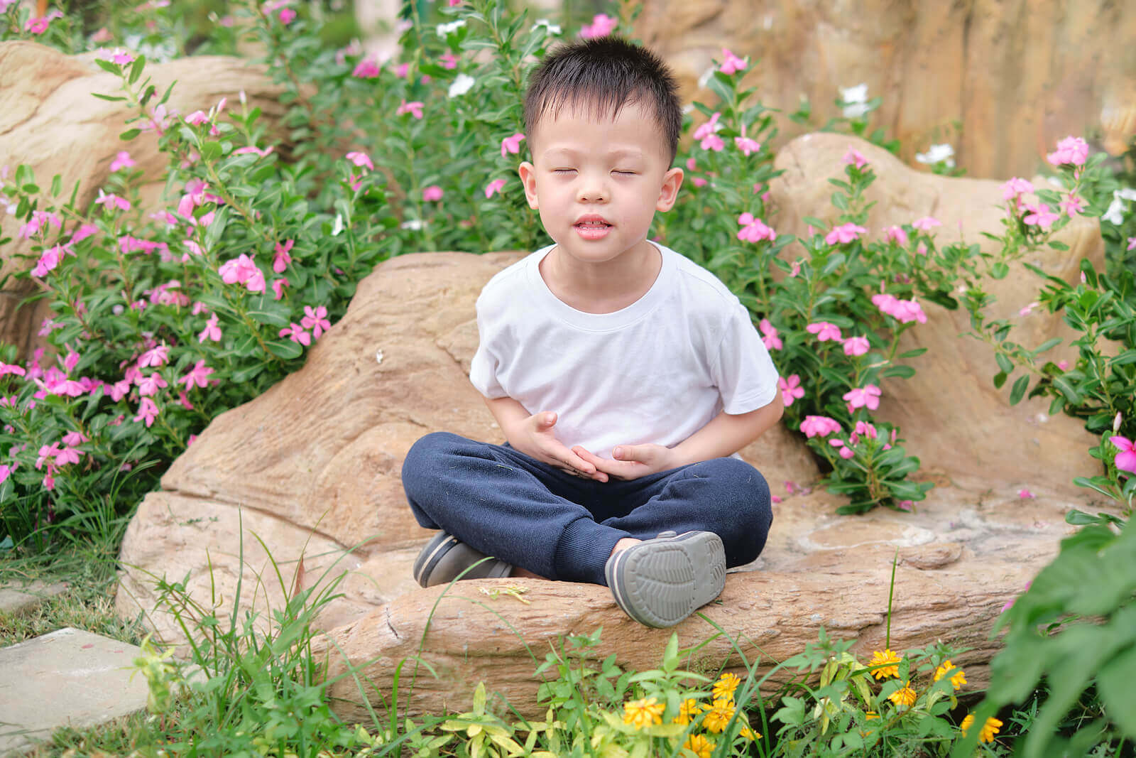 A small boy sitting with his legs crossed.