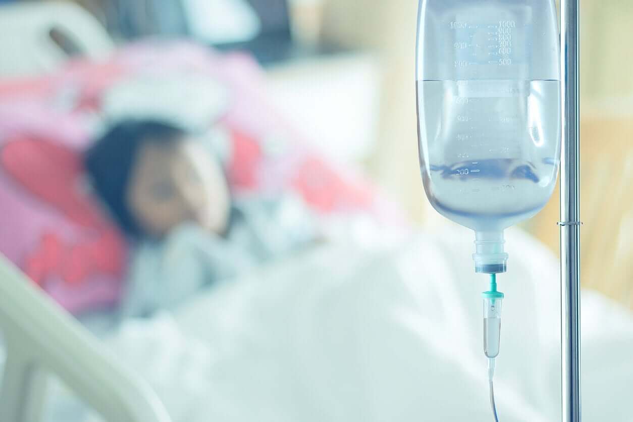 A child in a hospital bed connected to an IV drip.