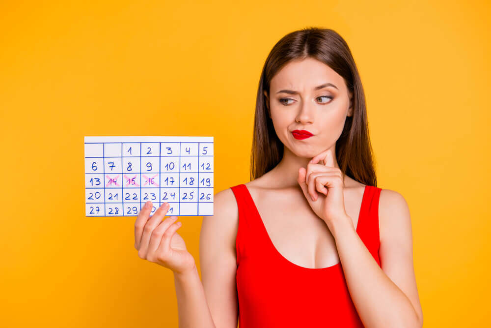 En kvinne som ser på menstruasjonskalenderen hennes.