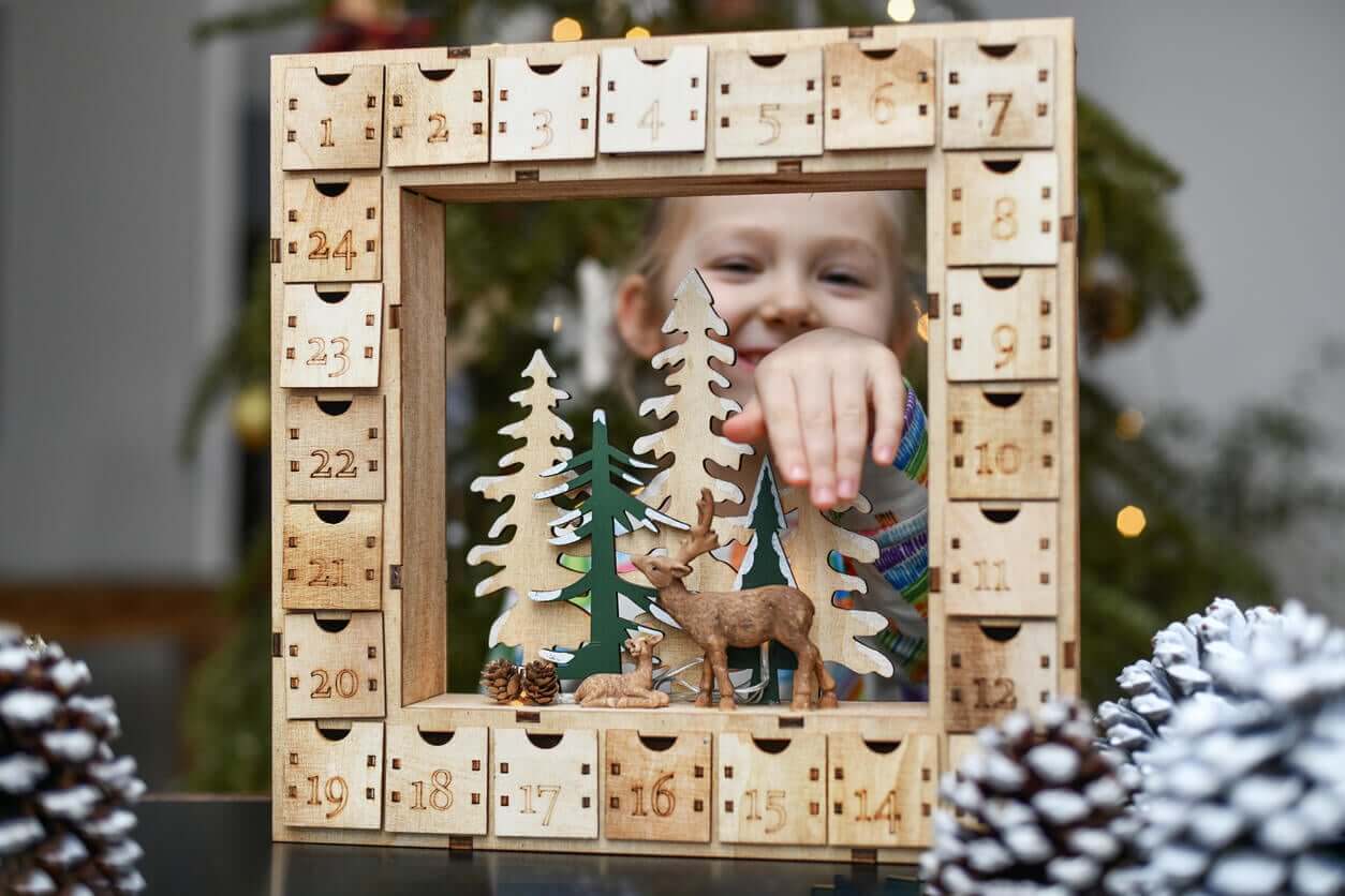 A little girl playing with an advent calendar.