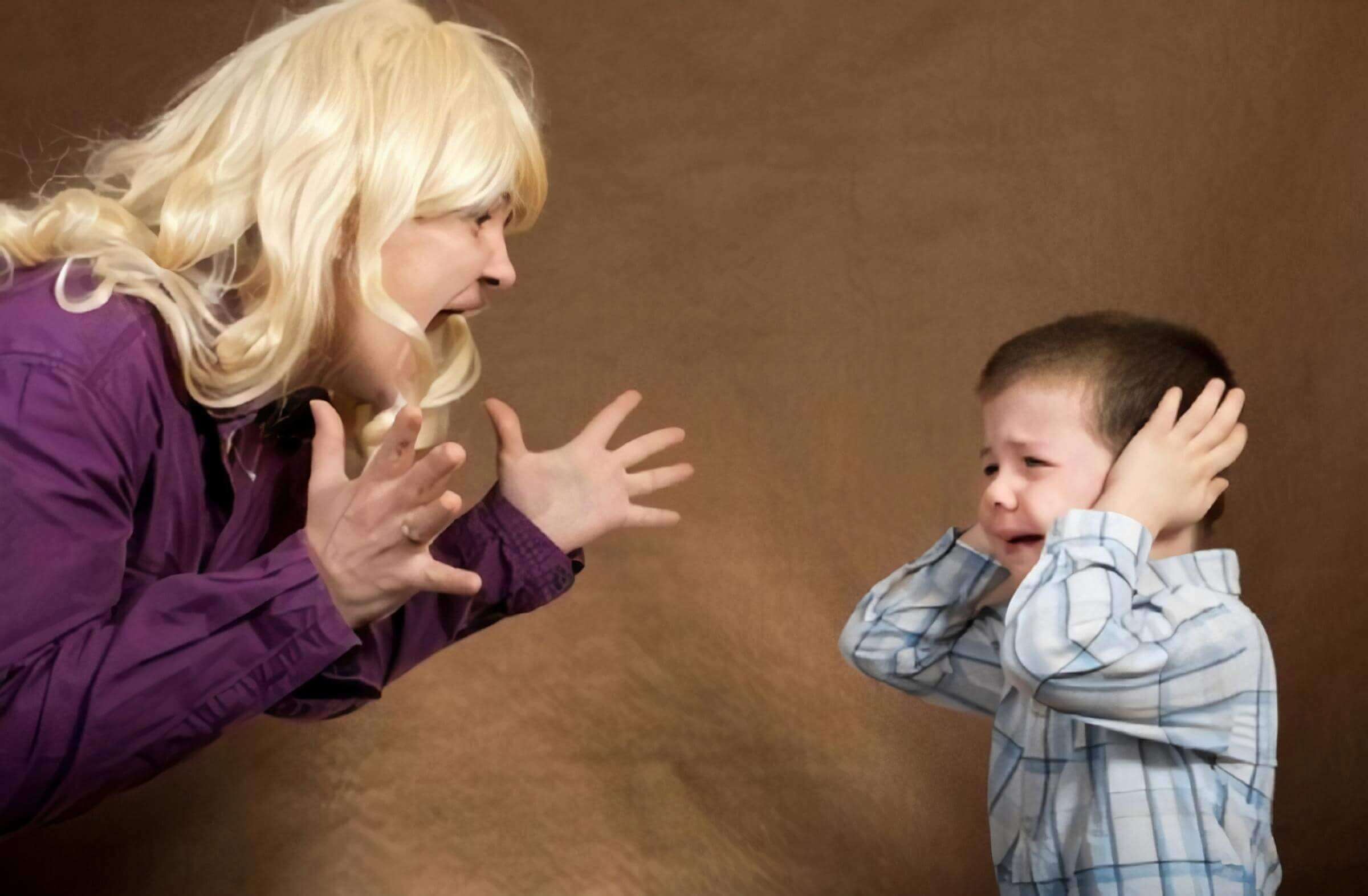 A woman screaming at a toddler boy who's covering his ears and crying.