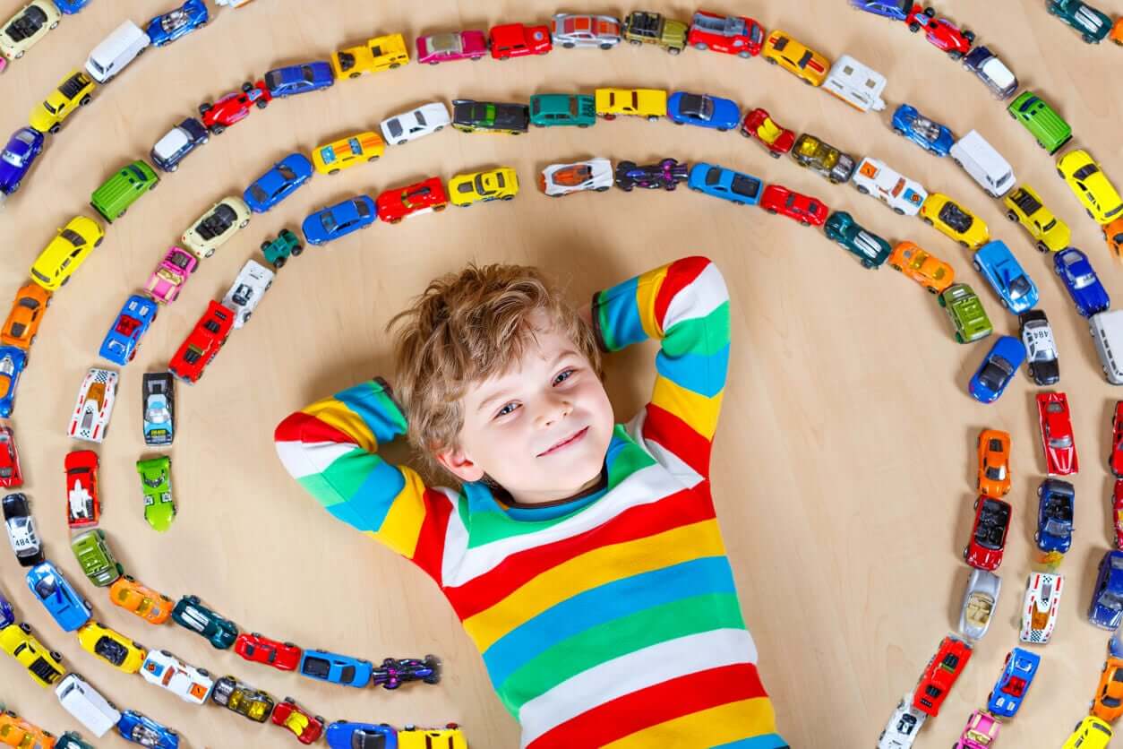 A child surrounded by his toy car collection.
