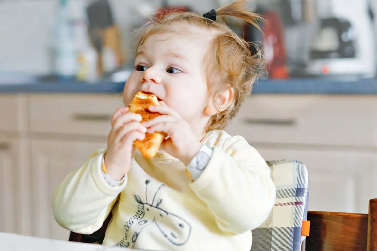 A baby gnawing on bread.
