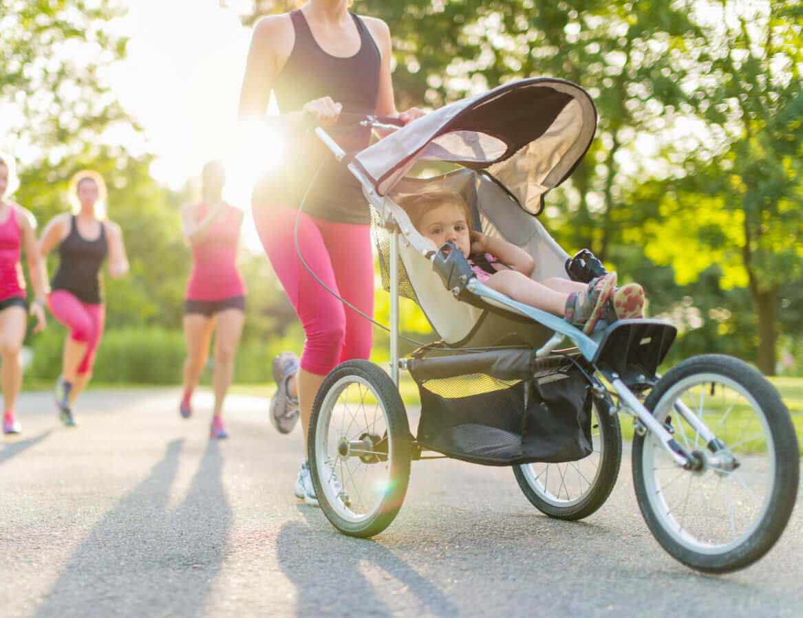 A woman jogging with her daughter in a stroller.