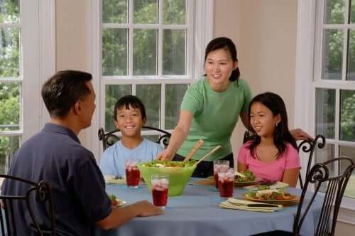 An Asian family sitting down to eat a healthy meal.
