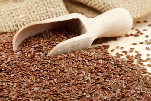 A wooden scop in a pile of flaxseed.