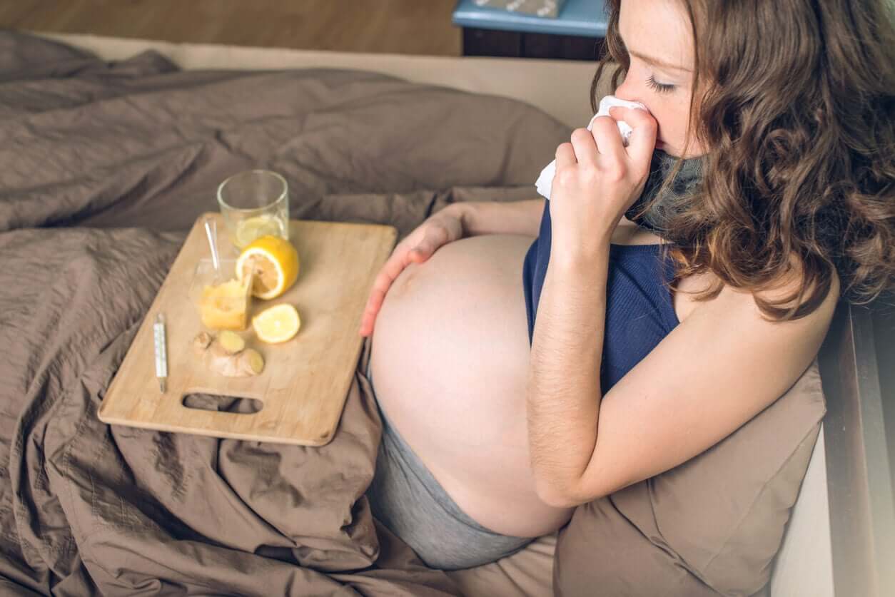 A pregnant woman with a cold drinking lemon and ginger tea.