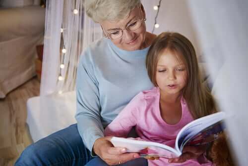 A young girl reading a bok to her grandmother.