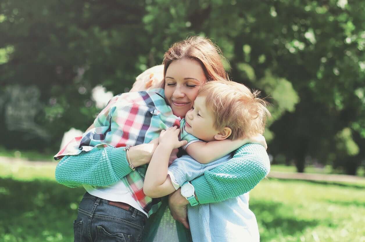 A mother hugging her small children.