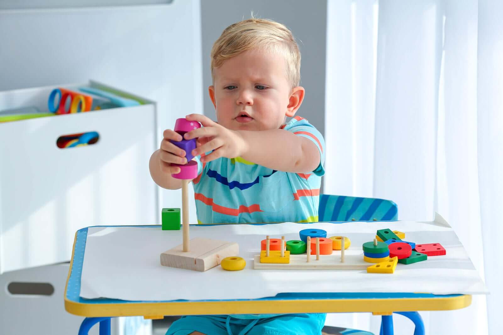 A toddler playing with wooden toys.