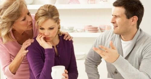 An older woman whispering into a younder woman's ear.