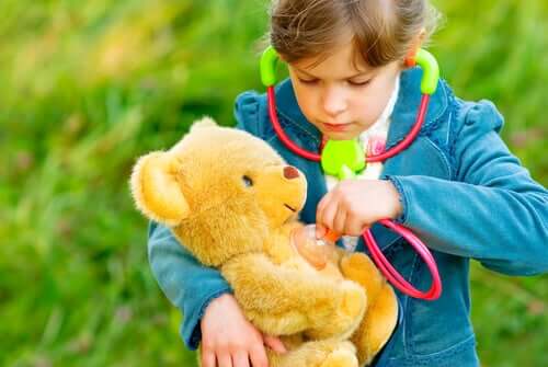 A child checking her teddy bear with a stethescope.