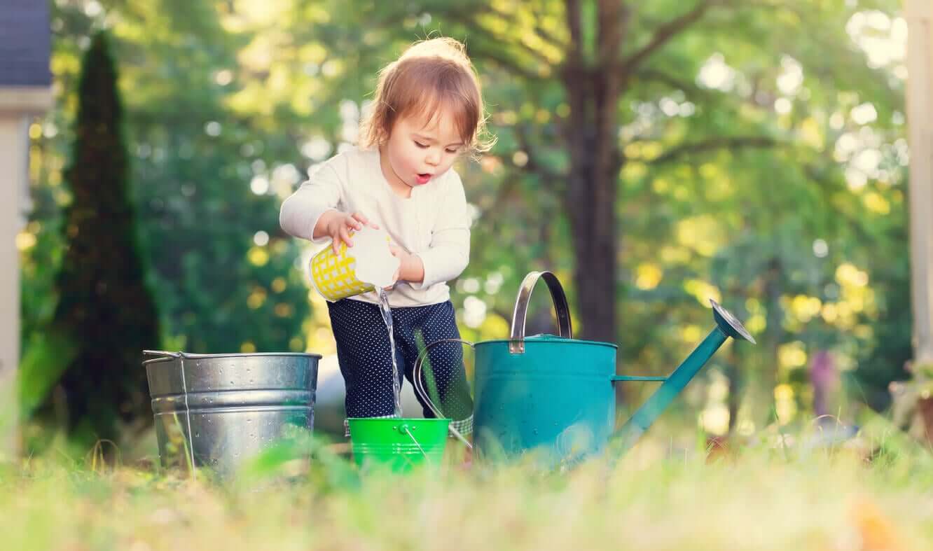 A child pouring water from one bucket to another.