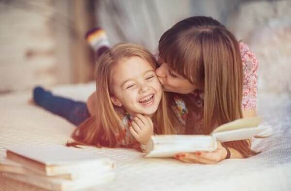 A mother and her daughter reading in bed.