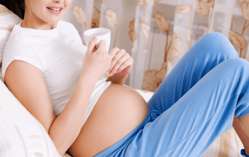 A pregnant woman drinking tea.