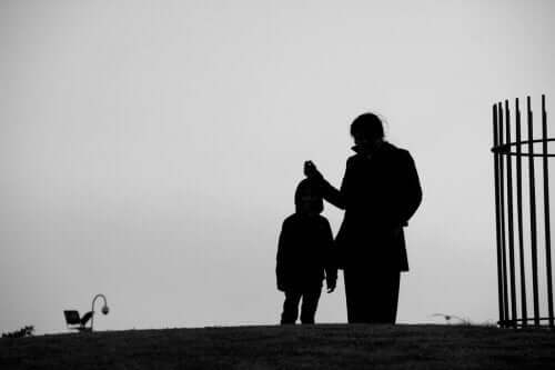 A black and white picture of a mother walking in the park with her child.