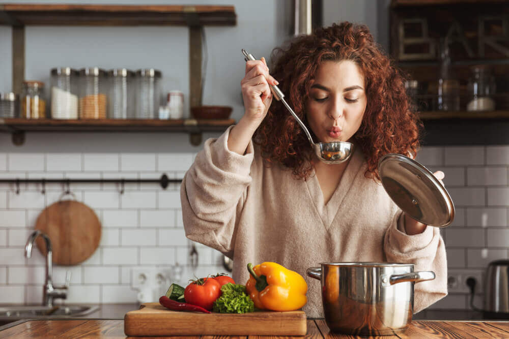 A woman preparing a vegetable soup.