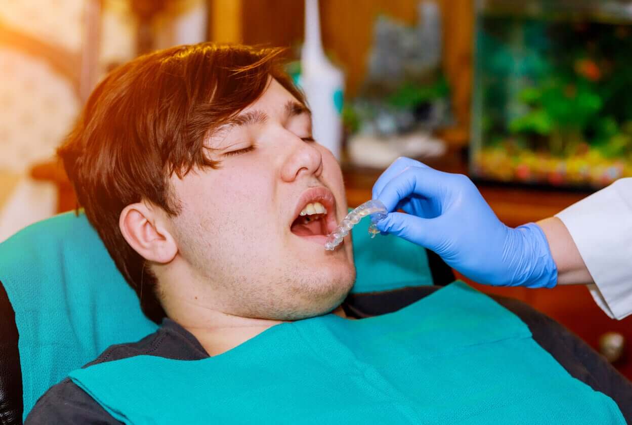 An orthodontist fitting a teen for invisalign.